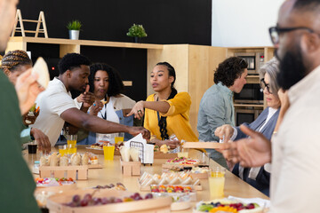 Office social gathering with diverse colleagues and snacks