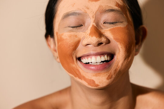 Woman Laughing with Clay Mask On
