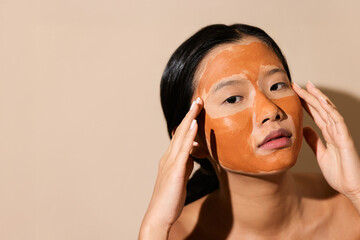Woman Touching Clay Mask on Face