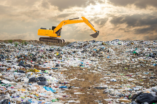 backhoe and truck is dumping the gabage from municipal,garbage dump pile and dark sky background ,pollution concept