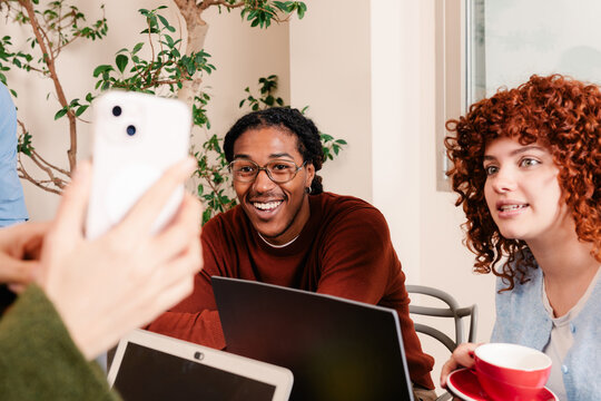 Colleagues enjoying some leisure time, looking at a smart phone
