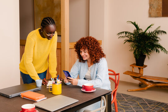 Office workers use a smart phone to communicate with their work teams