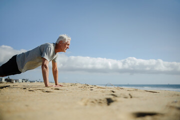 Fit Senior Exercising on Sunny Beach in Sand
