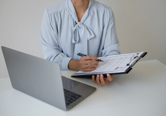 Businesswoman employer sitting holding new employee's documents to evaluate and review new employee's personal history. Recruitment concept, job placement