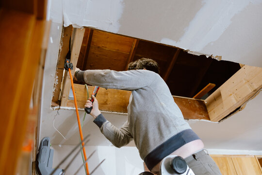 Father Fixing Attic Entrance in Garage