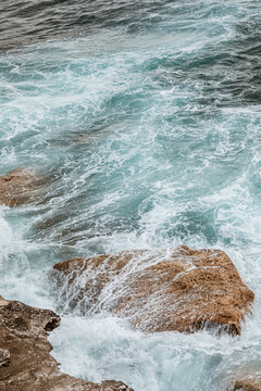 Waves crashing on rocky shoreline at dawn in Australia