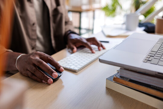 Midsection of man using keyboard and mouse while working from home