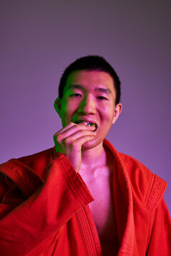 Young athlete putting a mouthguard wearing a red sports uniform