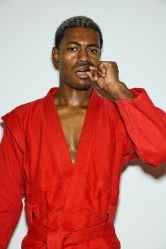 Young man in red martial arts uniform put bucal protector