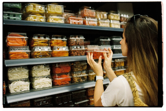 Woman buying dried fruit and nuts at the supermarket, film close up