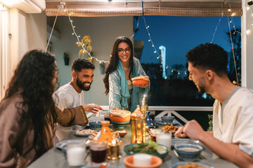 Young Muslim woman serving food for Iftar 