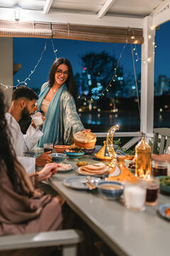 Young Muslim woman serving food for Iftar 