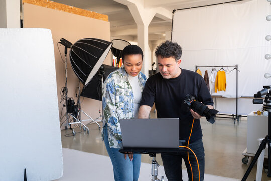 Photographer Showing Client Results Of Photoshoot In Studio