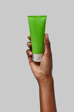 Woman holding a green cream tube