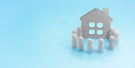 family house Wooden figures on a blue background. figures around the house. family traditions, copy space