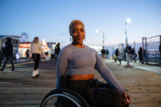 Confident Woman in a Wheelchair Enjoying the Amusement Park at Night