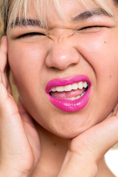 Playful Young Woman Making a Funny Expression with Pink Lipstick