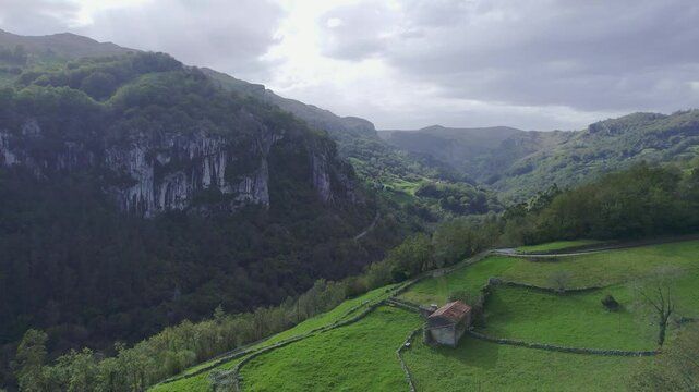 Aerial view of drone of a green landscape and an small cotage in a interior village of cantabia, Spain. 4k drone video
