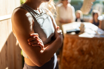 Yoga instructor crossing arms while leading group meditation session