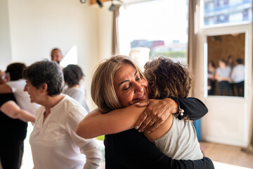 Women hugging during group therapy session showing support and empathy