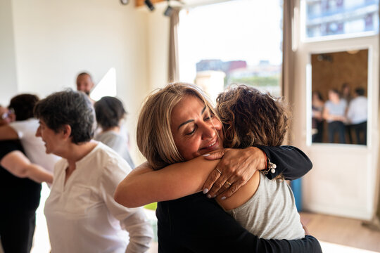 Women hugging during group therapy session showing support and empathy