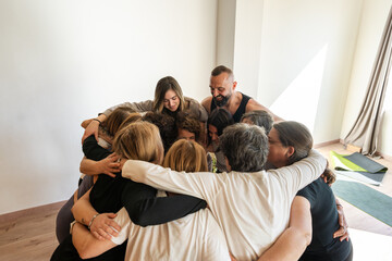 Group of People Hugging in a Circle During Therapy Session