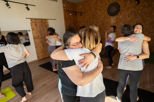 Group of women hugging each other during yoga therapy