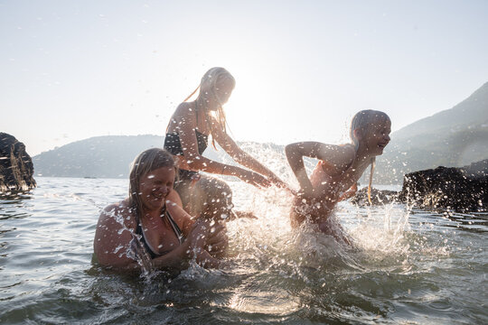 Woman and children fooling around in the sea