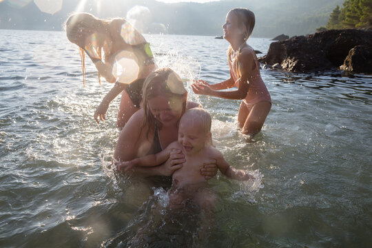 Mother and children fooling around in the sea