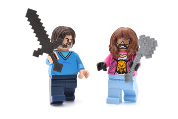 Fototapeta premium Lego minifigures of Garrett and Steve main character from video game Minecraft movie are going with weapons or swords. Editorial illustrative image of popular plastic toys.