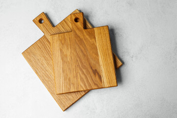 Wooden cutting boards stacked on a light surface in a kitchen setting