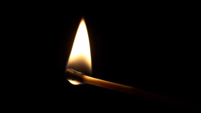 a lit matchstick in the dark with a lit match
