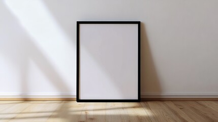 A simple black frame sits on a wood floor against a white wall.  It's perfect for showcasing your design.
