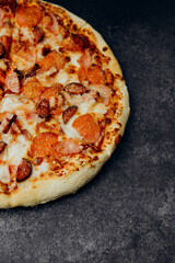 Delicious pepperoni and sausage pizza on a dark surface at a restaurant