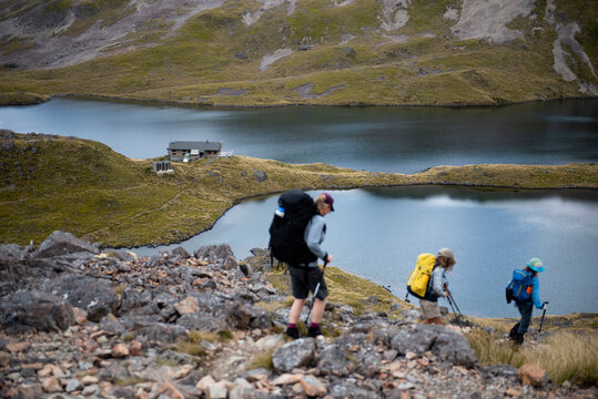 Hiking family descending to Angelus Hut, Souh Island, New Zealand
