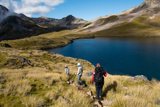 Family hiking in the mountains near an alpine lake, New Zealand