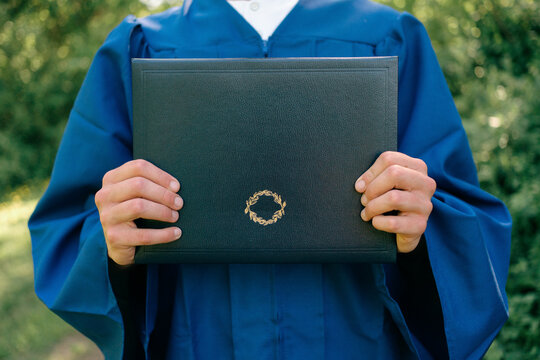 close up of young man holding High school certificate 