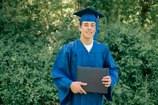  teenager/ young man posing  for photos with diploma/certificate