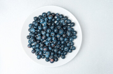 Fresh blueberries arranged on a white plate ready for consumption or recipe