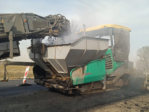 Asphalt paver at work on the road.