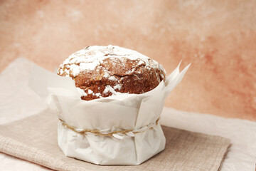 Traditional Easter cake with powdered sugar on soft beige linen background. Rustic homemade dessert for spring holiday