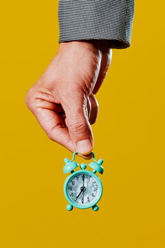 man holding an alarm clock with broken glass