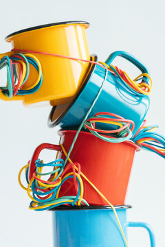 Colorful stacked mugs with vibrant rubber bands intertwined