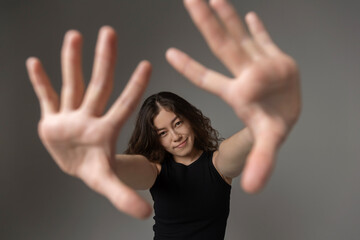 Young woman with curly hair showing her hands to the camera