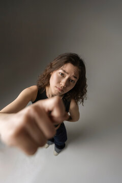 Young woman pointing finger blaming accusing someone 