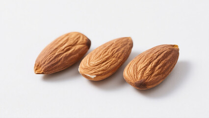 Isolated brown almonds, a healthy nut food and snack, are presented in a close-up group on a white background