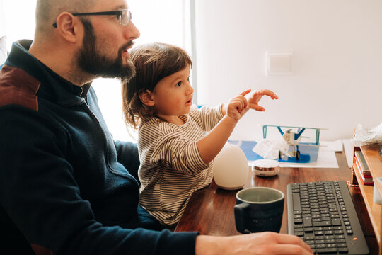 Father and daughter interacting at a home workspace