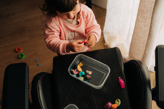 Toddler playing with colorful modeling clay indoors
