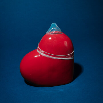 a condom covers a heart, on a square format