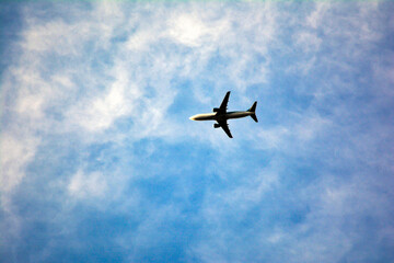 Airplane flying in the blue sky on a sunny day. Airplane flying in the blue sky with white clouds in the background